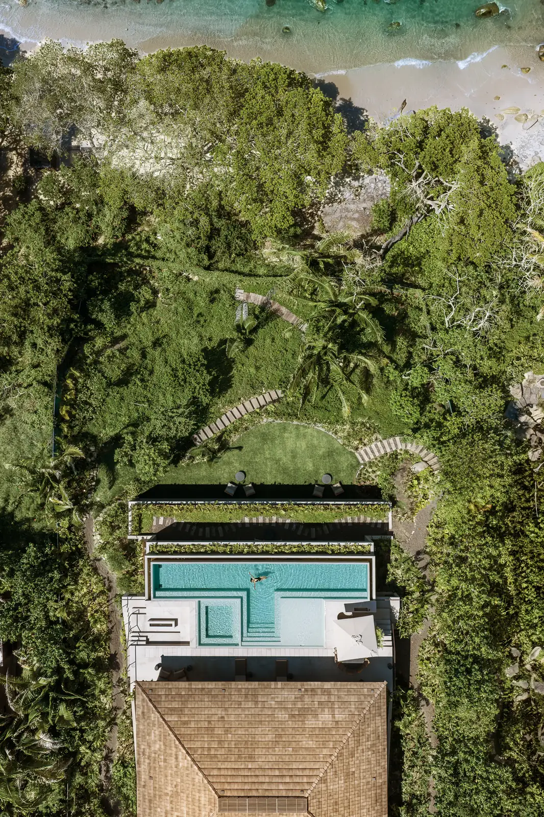 Villa Taiyari from directly above: the roof, the pool and the lawn, with the garden and trees running down to the beach